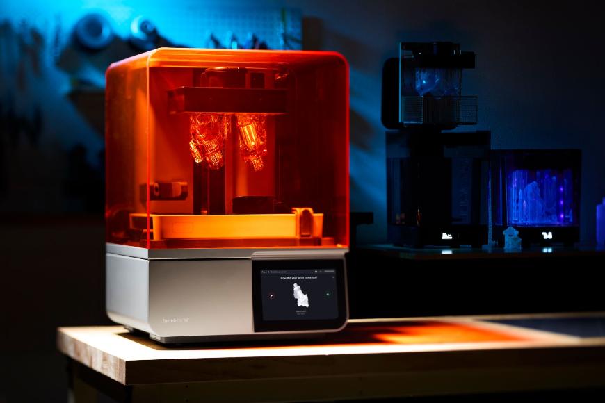 Mit dem Formlabs Form 4 Schnell detailierte Bauteile produzieren. Der Formlabs Form 4 steht auf einer Werkbank