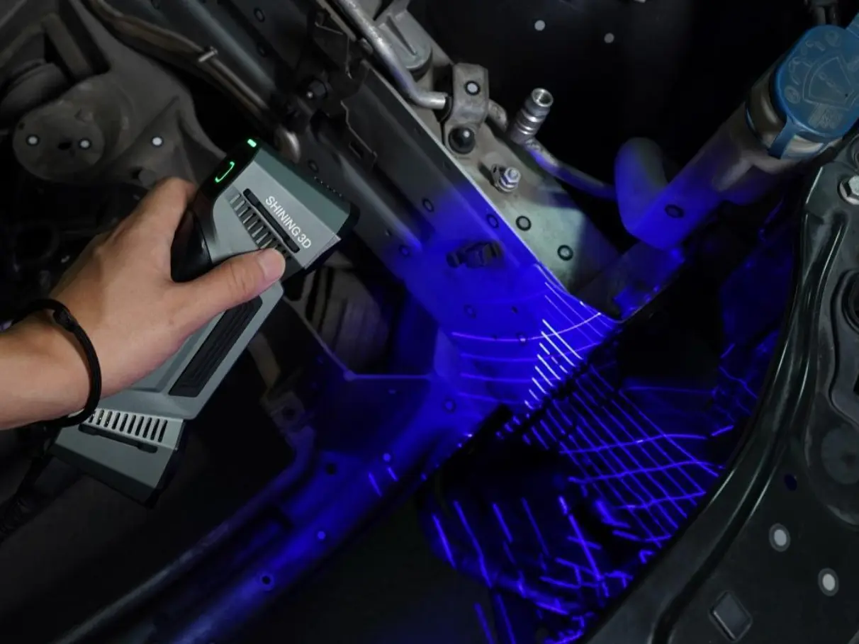 Der Motorbereich von einem Auto wird mit einen Hand 3D Scanner von Shining3D eingescant